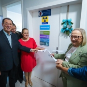 Secret&aacute;ria Arita e integrantes do hospital desatam fita inaugural branca em frente a porta da nova UTI adulto.