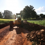 Foto mostra m&aacute;quina em trabalho na estrada vicinal
