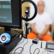 Foto mostra equipamento de captura de imagem com preso desfocado ao fundo