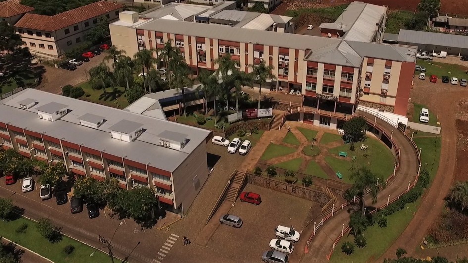 Vista a&eacute;rea do Hospital S&atilde;o Jo&atilde;o Batista. A foto mostra um complexo hospital com dois edif&iacute;cios e estacionamento. 