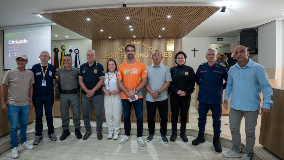 Dez pessoas est&atilde;o lado a lado de p&eacute; em pose para foto em um grande sal&atilde;o da C&acirc;mara de Vereadores de Xangri-l&aacute;