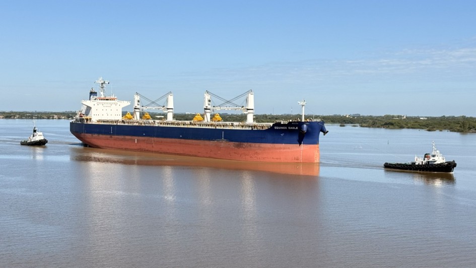 Foto mostra navio no Gua&iacute;ba, com c&eacute;u azul ao fundo. Na frente, uma lancha menor acompanha o caminho da embarca&ccedil;&atilde;o maior.