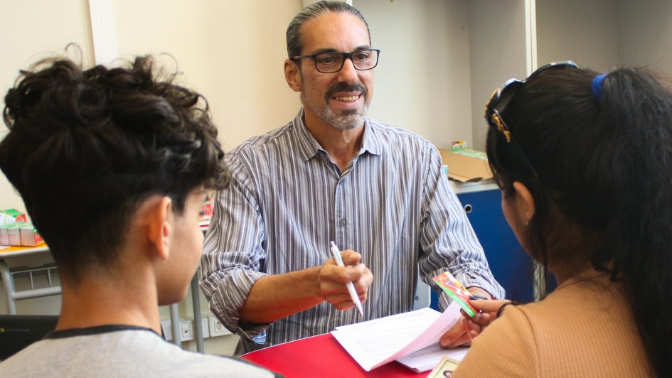 Foto mostra servidor entregando cart&atilde;o do Programa P&eacute; no Futuro &agrave; m&atilde;e e estudante.