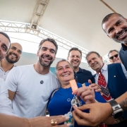 Um grupo de pessoas est&aacute; em p&eacute;, posando para a foto. Ao centro, uma mulher segura e exibe um molho de chaves, ao lado do governador Eduardo Leite e do vice-governador Gabriel Souza. 