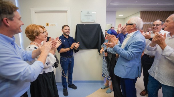 Vice-governador Gabriel Souza e secret&aacute;ria Arita Bergmann em frente a placa com outras autoridades. Todos batem palmas. 