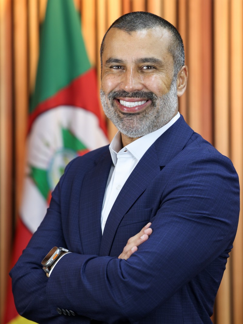 Homem de barba sorrindo e vestido de forma elegante
