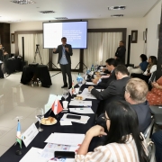 Foto mostra o secret&aacute;rio Gilmar Sossella falando aos outros secret&aacute;rios. Ele est&aacute; de p&eacute; ao microfone, os demais est&atilde;o sentados. 