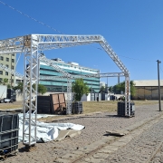 A imagem mostra estruturas em montagem ao ar livre. 