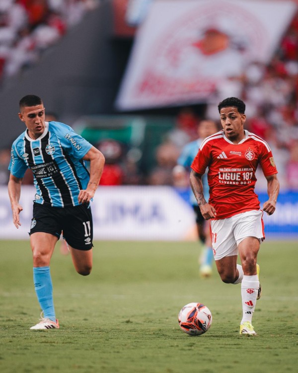 Lance do Gre-Nal deste domingo, mostrando jogadores com mensagem estampada nas camisetas incentivando a denúncia contra a violência de gênero