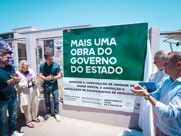 Foto mostra o governador Eduardo Leite e autoridades na inauguração de unidade na Santa Casa de Alegrete. Eles aplaudem em direção a placa do governo do Estado sobre a obra.