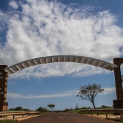 Imagem do pórtico de São Nicolau sobre a rodovia. À esquerda, uma coluna de tijolos tem a inscrição "Bem vindos à São Nicolau". No lado direito da rodovia, um arco em estilo missioneiro contorna uma cruz missioneira.