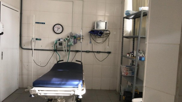 Foto mostra como era antes o Pronto atendimento do Hospital Regional de Rio Pardo. Os equipamentos eram antigos e muitos utensílios espalhados. Paredes eram antigas com azulejo branco.