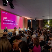 Foto mostra palestrantes falando para plateia.