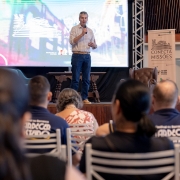 Secret&aacute;rio Loureiro falando durante evento no palco, com microfone, diante da plateia.