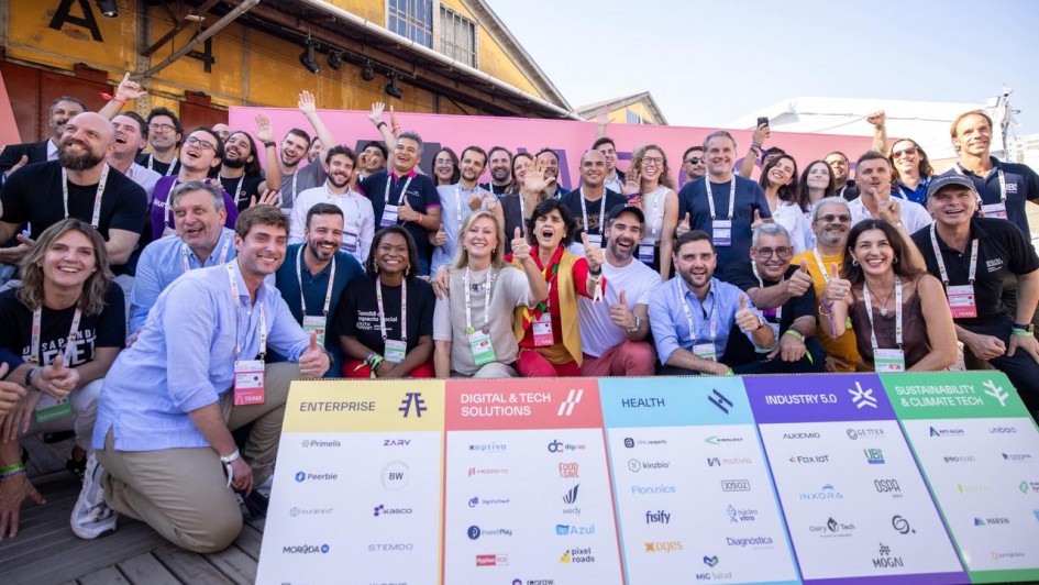 Foto mostra governador Eduardo Leite e outras autoridades e participantes do South Summit reunidos para uma foto coletiva. Todos vibram e alguns fazem sinal de positivo com a m&atilde;o. Eles est&atilde;o na frente de uma placa com logomarcas do evento. A foto foi realizada na parte externa do cais Mau&aacute;, com parte dos armaz&eacute;ns aparecendo ao fundo.