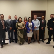 A foto registra um grupo alinhado em frente &agrave; porta da Central Integrada de Alternativas Penais. As pessoas est&atilde;o organizadas lado a lado em ambiente interno de paredes claras.