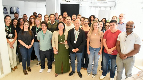 A imagem mostra um grupo numeroso reunido em ambiente interno, organizado para registro coletivo durante um encontro institucional.