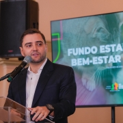 Foto mostra o vice-governador Gabriel Souza discursando no p&uacute;lpito. Atr&aacute;s dele, h&aacute; uma tela com um t&iacute;tulo "Fundo Estadual de Bem-Estar Animal.