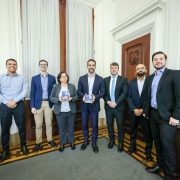 Foto mostra o governador Eduardo Leite com a secret&aacute;ria da Fazenda, Pricilla Santana, o contador e auditor-geral do Estado, Carlos Geminiano Rodrigues, e equipe da Contadoria e Auditoria-Geral do Estado (Cage). Governador e secret&aacute;ria asseguram exemplares do Balan&ccedil;o Geral do Estado nas m&atilde;os. 