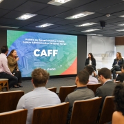 Foto mostra apresenta&ccedil;&atilde;o do projeto. No palco quatro debatedores falam sobre a proposta diante da plateia. 