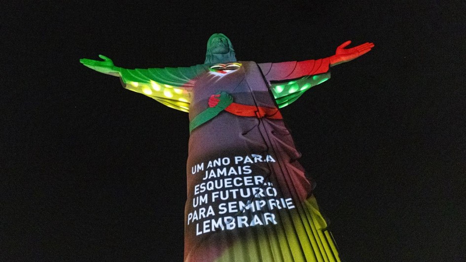 Imagem do Cristo Protetor de Encantado, com mensagem projetada sobre as cores do Rio Grande do Sul: um ano para jamais esquecer, um futuro para sempre lembrar