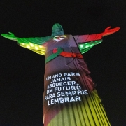 Imagem do Cristo Protetor de Encantado, com mensagem projetada sobre as cores do Rio Grande do Sul: um ano para jamais esquecer, um futuro para sempre lembrar