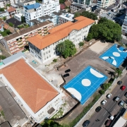 Vista a&eacute;rea destacando um pr&eacute;dio antigo de telhado avermelhado em processo de reforma.