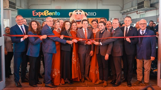 V&aacute;rias pessoas est&atilde;o paradas atr&aacute;s de uma fita inaugural da Expobento e Fenavinho em Bento Gon&ccedil;alves 