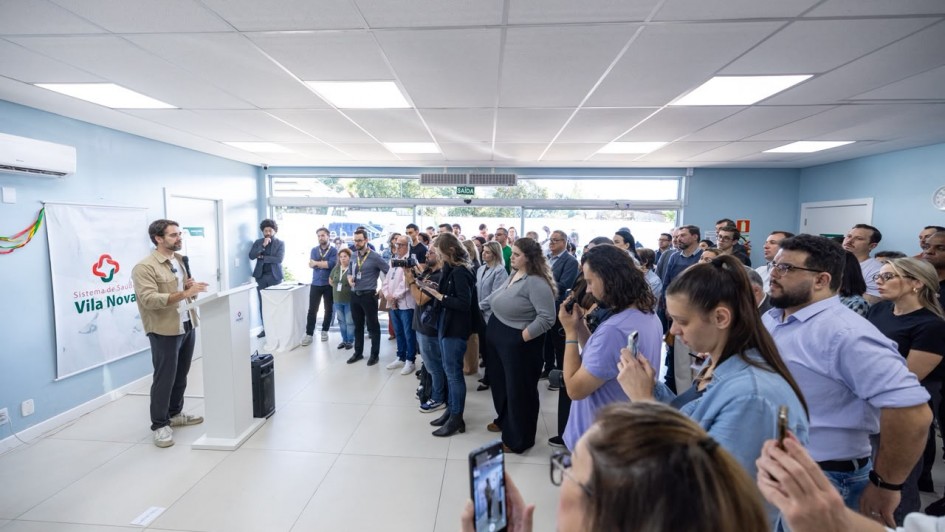 O governador fala ao microfone para um p&uacute;blico numeroso em uma unidade sa&uacute;de. 
