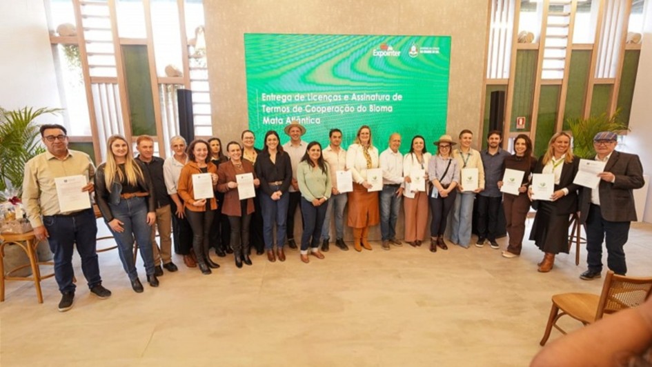 Foto mostra grupo posando para foto, exibindo documentos das licen&ccedil;as.