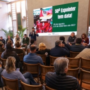 Foto mostra secret&aacute;rio falando durante a coletiva, diante da plateia. Ele est&aacute; em p&eacute; em frente aos participantes, que est&atilde;o sentados. Ao fundo, uma tela com a apresenta&ccedil;&atilde;o.