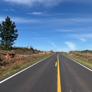 Foto mostra a rodovia com asfalto novo. Ela segue em dire&ccedil;&atilde;o ao horizonte. O c&eacute;u est&aacute; azul e com poucas nuvens. 