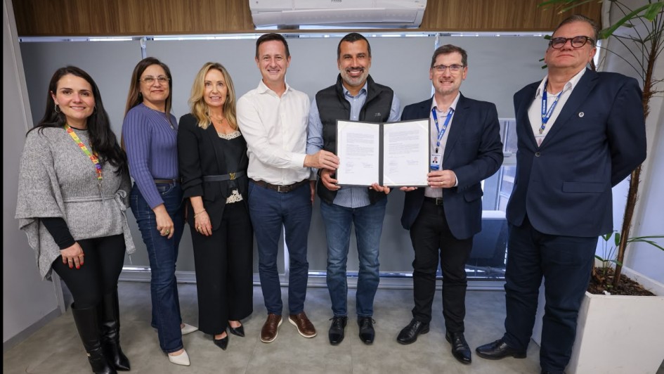 Foto mostra o titular da Sehab e o presidente da Emater, segurando juntos o documento assinado, ao lado de outros integrantes. 