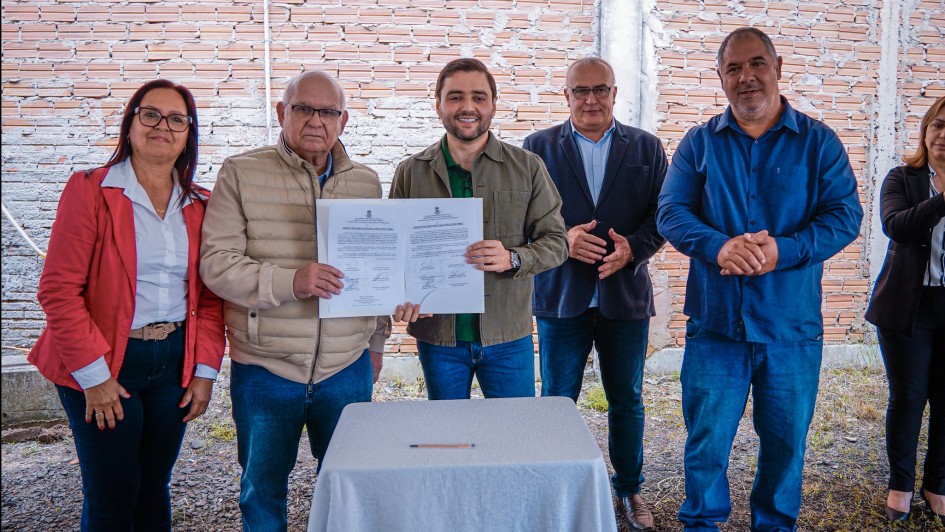 Foto mostra o vice-governador Gabriel Souza segurando o documento assinado com o prefeito. Outras autoridades est&atilde;o juntos na foto e aplaudem o ato.